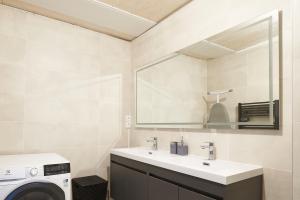 a bathroom with a sink and a washing machine at Duplex de standing en plein coeur de Béziers in Béziers