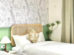 a bedroom with a bed with a rattan headboard at 永安101 Wing on x 附陽台 in Taitung City +31 photos