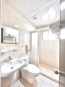 a white bathroom with a toilet and a sink at 永安101 Wing on x 附陽台 in Taitung City
