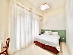 a bedroom with a bed and a large window at 永安101 Wing on x 附陽台 in Taitung City
