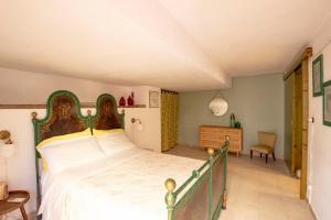 een slaapkamer met een groot bed en een stoel bij Casa Pein in Carloforte +27 foto's