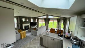 - un salon avec des canapés et une télévision dans l'établissement Macaw Lodge, à Malton