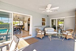 a living room with a ceiling fan and a table and chairs at West Boca Seashell House in Boca Raton