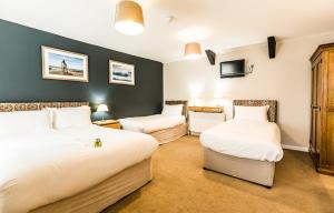 Habitación de hotel con 2 camas y TV en King Arthurs Arms en Tintagel