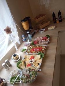 une table avec plusieurs assiettes de nourriture sur un comptoir dans l'établissement Bożenka, à Niechorze