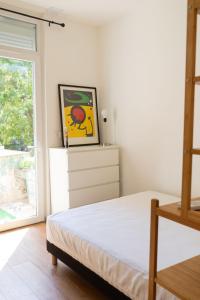 マルセイユにあるLE PETIT NID DES CHUTES LAVIESのベッドルーム1室(ベッド1台付)が備わります。壁には絵画が飾られています。