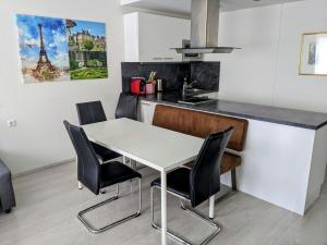 kuchnia z białym stołem i czarnymi krzesłami w obiekcie 204 Paris 59m2 4-8 Pers extr Bedroom w mieście Klagenfurt