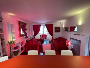uma sala de estar com sofás vermelhos e uma mesa e cadeiras em Red Flat Paris em Paris