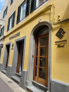 un edificio amarillo con ventanas y puertas en una calle en ROMANDRE en Alaior