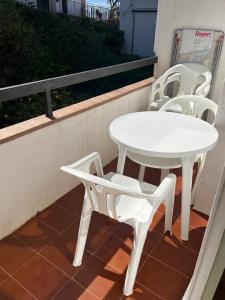 - Balcón con mesa blanca y sillas en Racó de Mar, en Palamós