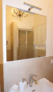 La salle de bains est pourvue d'un miroir, d'un lavabo et d'une douche. dans l'établissement La Casa di Zia Argia, à Montegiorgio