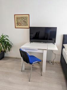 einen weißen Schreibtisch mit einem blauen Stuhl in einem Zimmer in der Unterkunft 102 Venedig 59m2, 4-8 Pers extra Bedroom in Klagenfurt am Wörthersee