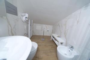 een witte badkamer met een toilet en een wastafel bij Slow Chic Apartment BeB Policlinico in Messina