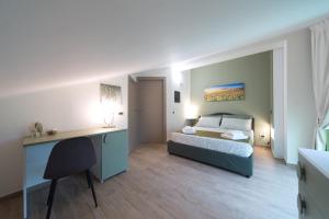 1 dormitorio con cama y escritorio en Slow Chic Apartment BeB Policlinico, en Messina