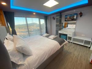 a bedroom with a bed with a desk and a window at La Vie En Rose Hotel by Sogutdagi Isparta in Keçiborlu