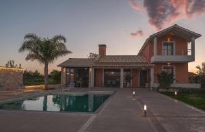 a house with a swimming pool in front of a house at Villa Manolia in Preveza