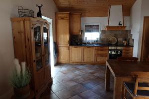 cocina con armarios de madera y suelo de baldosa en Chalet Giusto en Kötschach