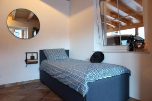 1 dormitorio con 1 cama con espejo en la pared en Chalet Giusto, en Kötschach-Mauthen