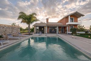 普雷韦扎Villa Manolia的一栋房子前面有游泳池