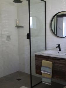 a bathroom with a sink and a mirror at Farm House Plettneberg Bay in Plettenberg Bay