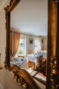 uno specchio che riflette una sala da pranzo con tavoli e sedie di Móinéir House a Kilkee