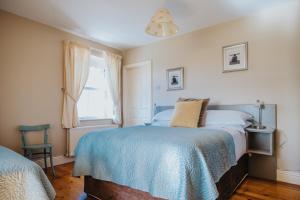 a bedroom with a bed with a blue blanket at Móinéir House in Kilkee