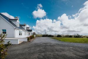 uma entrada vazia ao lado de uma casa branca em Móinéir House em Kilkee