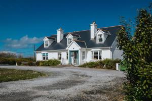 uma casa branca com um telhado preto em Móinéir House em Kilkee