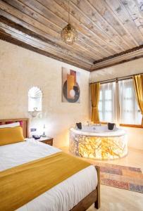a bedroom with a bed and a bath tub at Uzay Cave Suite Hotel in Urgup