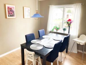 Gullringen的住宿－Villa with 4 bed rooms with internet in Vimmerby，一张带蓝色椅子和黑色桌子的餐桌