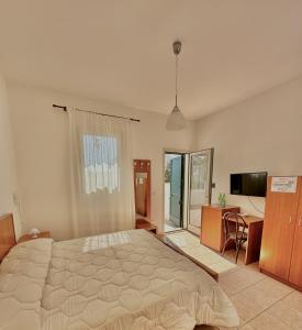Schlafzimmer mit einem Bett, einem Schreibtisch und einem TV in der Unterkunft Agriturismo Panacea in Santa Cesarea Terme