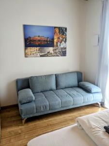 un sofá azul en una sala de estar con una foto en la pared en 215 Apartment Wien 4-6 Pers 42m2, en Klagenfurt