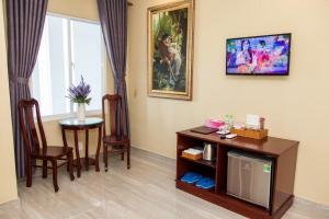 a living room with a tv and a table with chairs at Sea Memory Hotel in Vung Tau
