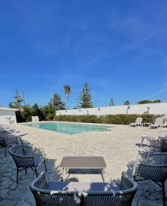 - une piscine avec des chaises et une table en face dans l'établissement Agriturismo Panacea, à Santa Cesarea Terme
