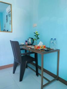 Cowang Dereng Home Stay في لابوان باجو: طاولة خشبية مع كرسي ومرآة