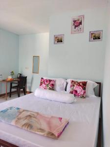 Un dormitorio con una cama con flores rosas. en Cowang Dereng Home Stay, en Labuan Bajo