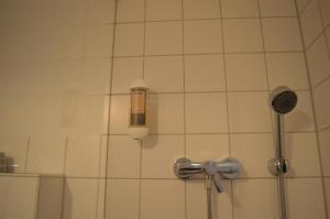 een badkamer met een douche en een fles aan de muur bij Burger Fährhaus in Burgerfeld