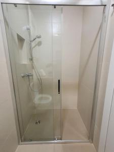 a shower with a glass door in a bathroom at Petra - Official 4* One Bedroom Apartment-Balcony in Zagreb
