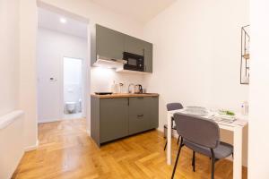 a kitchen with a table and chairs in a room at Petra - Official 4* One Bedroom Apartment-Balcony in Zagreb