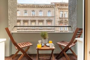 a table and chairs on a balcony with a view of a building at Petra - Official 4* One Bedroom Apartment-Balcony in Zagreb