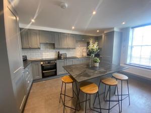 a kitchen with a large island with stools in it at The Old Gables in Brampton