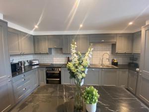 a kitchen with a vase of flowers on a table at The Old Gables, Brampton Town Centre, Hadrians Wall Sleeps 4 in Brampton +16 photos