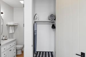 Baño blanco con espejo y lavabo en Casa Jardin - Boutique Suites in Downtown Santa Barbara en Santa Bárbara