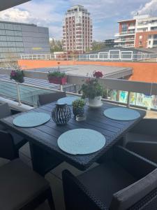 a black table on a balcony with plants on it at Appartement haut standing F2 Rivetoile Strasbourg centre parking gratuit terrasse in Strasbourg