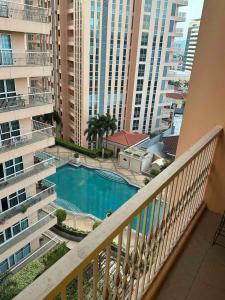 a balcony with a view of a pool and buildings at The Pearl - Venice Luxury Residences McKinley in Manila