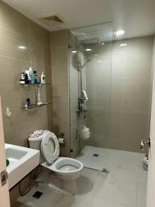 a bathroom with a shower and a toilet and a sink at The Pearl - Venice Luxury Residences McKinley in Manila