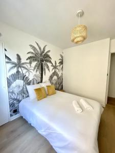 um quarto com uma grande cama branca com almofadas amarelas em La Douceur Roannaise - Parking privé proche gare em Roanne