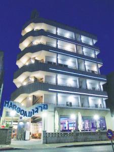 um edifício branco alto com um cartaz em Margoa Hotel Netanya em Netanya