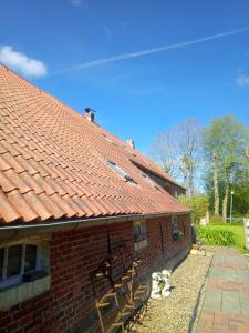 une maison en briques rouges avec un toit rouge dans l'établissement Alte Pastorei Jennelt, à Krummhörn