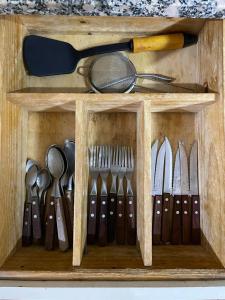 Una caja de madera con muchos utensilios. en Departamento Familiar Amplio y Luminoso en Rafaela en Rafaela